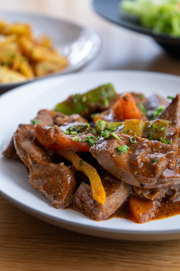 A mouthwatering plate of beef stir fry garnished with vibrant vegetables, perfect for a tasty dinner.