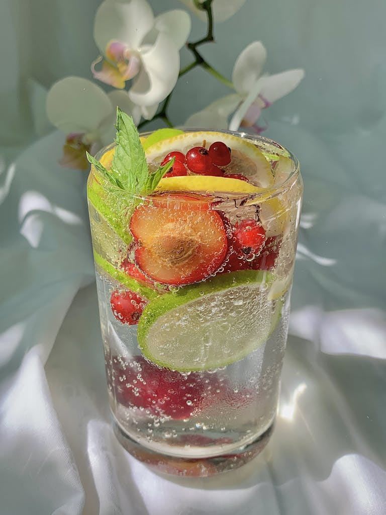 Vibrant citrus and berry-infused drink with mint, perfect for summer refreshment.